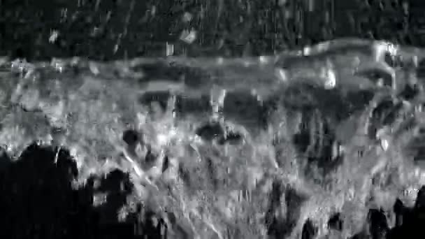 Unterwasserexplosion auf der Oberfläche auf schwarzem Hintergrund. Wasserblase platzt mit vielen Spritzern in Zeitlupe aus nächster Nähe. — Stockvideo