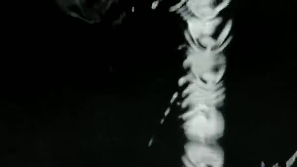 Flussi di acqua piovana cadono sul vetro della finestra e scorrono verso il basso in slow motion. Chiudi getti d'acqua su uno sfondo nero. — Video Stock