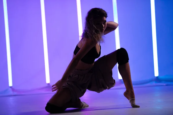 Retrato de uma dançarina contemporânea posando no estúdio contra o pano de fundo de lâmpadas de néon. Mulher dançando bela pose isolado fundo. — Fotografia de Stock