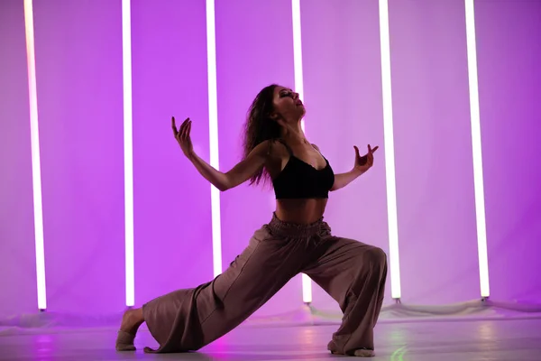 Beautiful modern dancer posing in the studio against the backdrop of neon lamps. — Stock Photo, Image