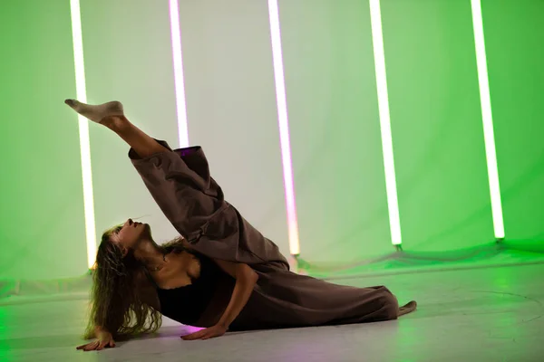 Nuoren naistanssijan muotokuva. Naisten moderni tanssi. Tanssija poseeraa studiossa neonvalojen taustaa vasten. — kuvapankkivalokuva