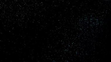 Harika bir kar yağışı. Siyah arka planda stüdyo ışıklandırmasıyla çekilen kar yavaş çekimi. Büyük kar taneleri düşer ve havada fırıl fırıl döner. Kapat..