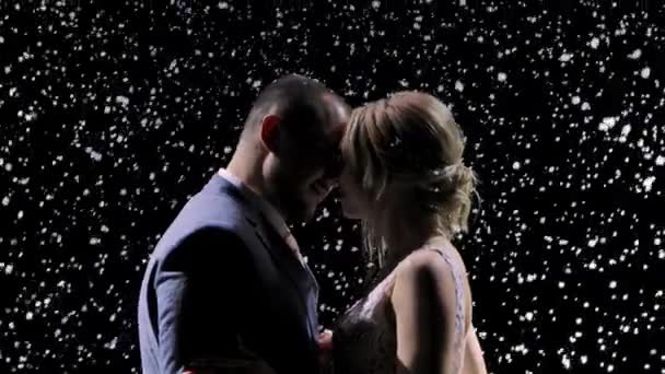 Любящая пара нежно целуется на фоне падающего снега. История любви, первый снег, романтика. Медленное движение. Закрыть. — стоковое видео