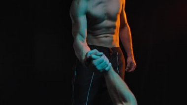 Siyah stüdyo geçmişinde iki kaslı adamın tokalaşması. Ağır çekim. Kapat..