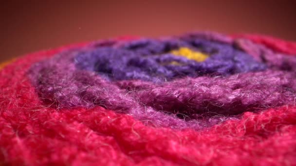Imágenes macro de textura de hilo de lana de colores. Una cámara deslizante vertical que se mueve a lo largo de una madeja de arco iris brillante. Dolly tiro de cerca. — Vídeos de Stock