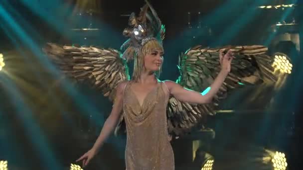 Řecká bohyně Artemis se zlatými křídly a elegantní čelenkou zpívá a tančí na jevišti. Mladá žena představuje divadelní vokální taneční show. Zavřít. — Stock video