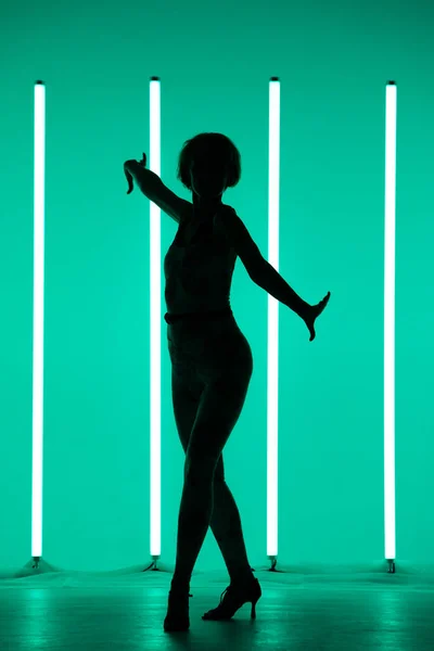 年轻的女体育舞蹈家在演播室里独唱,背景音乐五彩缤纷,配以霓虹灯灯管.舞蹈彩色海报. — 图库照片