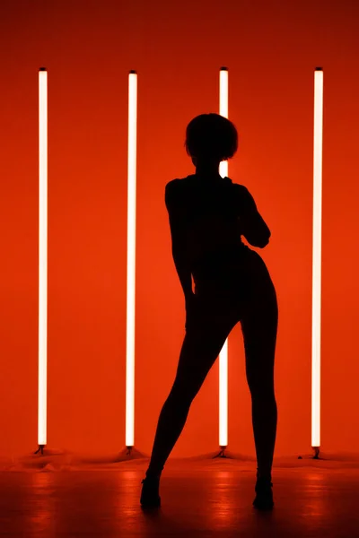Sport ung kvinna dansare utför solo i studion på en färgstark bakgrund med neon belysning röret. Dans färg affisch. — Stockfoto
