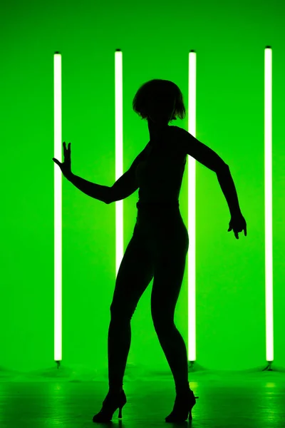 Jeune danseuse sportive se produisant en solo en studio sur un fond coloré avec tube lumineux au néon. Affiche couleur danse. — Photo