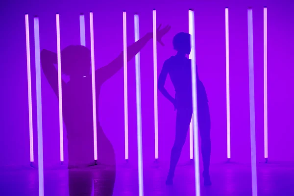 Collage van schaduwen sport jonge vrouw danser optreden solo in de studio op een kleurrijke achtergrond met neon lichtbuis. Danskleur poster. — Stockfoto