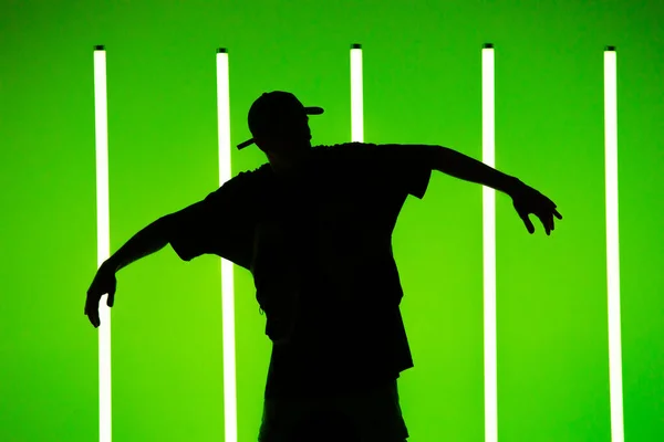 Een man die hedendaagse straatdans danst in de studio. Neon licht buis achtergrond. Acrobatische bboydanser. Schoolposter voor breakdancing. Sluiten.. — Stockfoto