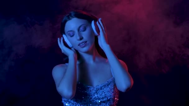 Ritratto di affascinante giovane donna sta ballando e godendo la musica in grandi cuffie rosse. Chiudete. Rallentatore. — Video Stock
