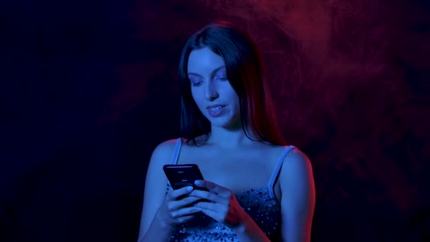 Портрет очаровательной молодой женщины, которая пишет смс на телефоне, показывает смартфон с зеленым цветовым ключом и указывает на него пальцем. Закрывай. Медленное движение. — стоковое видео