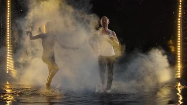 Yetenekli dansçılar karanlık bir odada konser ışıkları ve sigara altında salsa yapıyor. Şehvetli çift yağmur damlaları arasında sanatsal ve duygusal bir dans sergiliyor. Yavaş çekim.