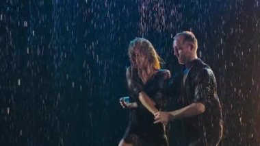 Tutkulu çift karanlık bir stüdyoda salsa dansı yapıyor. Bir erkek ve bir kadın siyah dumanlı bir arka planda coşkuyla dans ediyorlar. Ağır çekim. Kapat..