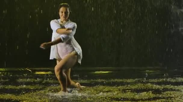 Bailarina bailando elementos de salsa bajo la lluvia. Silueta de una mujer con ropa mojada disfrutando del baile. En cámara lenta. De cerca.. — Vídeos de Stock