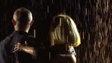 Dans partnerleri, parlayan yağmur damlaları arasında karanlık bir stüdyoda gösteri yapıyorlar. Çift ağır çekimde salsa yapmayı sever. Kapat..