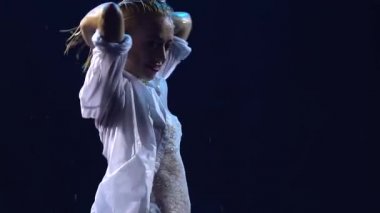 Karanlık bir stüdyoda, suyun üstünde seksi seksi bir hareket ve saçlar serpiştiriyor. Beyaz bir vücut giysisi içinde ıslak bir kadının silüeti. Ağır çekimde kapat..