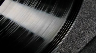 Pikapta dönen siyah, parlak, vinil plağın aşırı yakın çekimi. Antika nostalji. Üst Manzara. Yavaş çekim.