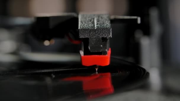 Vinyl plaat draait in de grammofoonspeler en speelt een oude disco. De audiokop hangt over het vinyl en de stereo naald leest de opname van groeven op de schijf. Sluit maar af. Langzame beweging. — Stockvideo