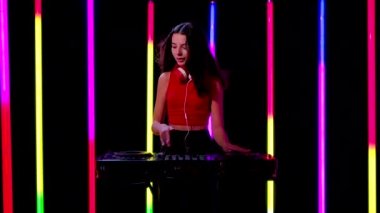 Büyük kırmızı kulaklıklı güzel bir kadının portresi elektronik müzik çalar ve dans eder. Yavaş çekim.