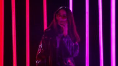 Şık güneş gözlüklü, akıllı telefonuyla konuşan güzel genç bir kadının portresi. Yavaş çekim.