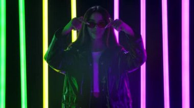 Şık güneş gözlüklü güzel bir kadının portresi kameraya bakarken elleriyle bir kalp hareketi gösteriyor ve hava öpücüğü gönderiyor. Yavaş çekim.