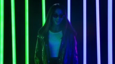 Güneş gözlüğüyle kameraya bakan genç ve güzel bir kadının portresi güzel bir jest gösteriyor. Yavaş çekim.