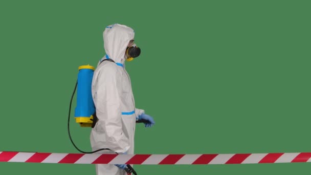 Trabajador desinfectante en un traje blanco protector, respirador y gafas hace que la desinfección en la clave de croma pantalla verde aislada. En cámara lenta. De cerca.. — Vídeo de stock