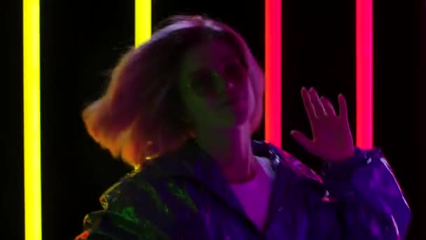 Portret van een jonge stijlvolle vrouw in een zonnebril die danst op snelle muziek. Sluit maar af. Langzame beweging. — Stockvideo