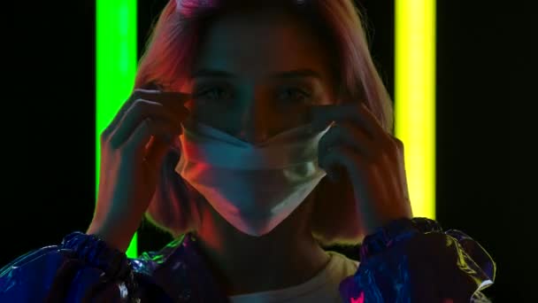 Portrét mladé stylové ženy, která se dívá do kamery, si nasadí a pak sundá lékařskou masku. Zavřít. Zpomalený pohyb. — Stock video