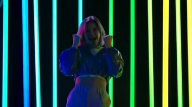 Genç ve şık bir kadının kameraya bakan portresi zafer dansı yapıyor. Yavaş çekim.