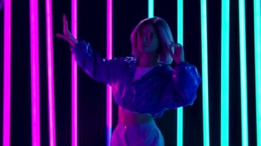 Yavaş müzikle dans eden güneş gözlüklü genç bir kadının portresi. Yavaş çekim.