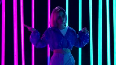 Güneş gözlüklü, dans eden ve sakız çiğneyen genç bir kadının portresi. Yavaş çekim.