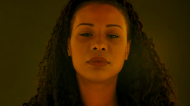 Porträtt av en ung vacker kvinnlig afroamerikan som tittar på kameran. Närbild. Långsamma rörelser. — Stockvideo