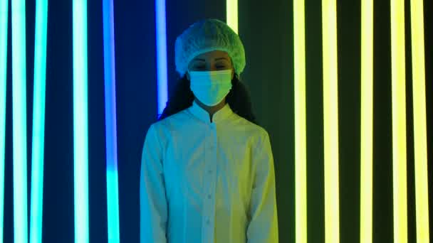 Portrait of a young lovely female African American in protective medical clothing and gloves looking at the camera and removes the medical mask. End of quarantine. Slow motion. — 图库视频影像