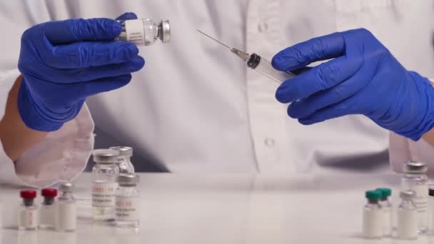 Ανάπτυξη και δημιουργία εμβολίου κατά του ιού του στομίου COVID-19. Επιστήμονας με μπλε γάντια γεμίζει τη σύριγγα με εμβόλιο κατά της γρίπης και του ιού της στέψης. Κλείσε. Αργή κίνηση. — Αρχείο Βίντεο