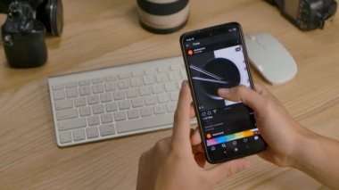 Editör görüntüleri: Bir adam akıllı telefonu için cep telefonu uygulaması kullanarak Shutterstock 'taki fotoğraflara göz atıyor. Eller yukarı. Kapatın. Yavaş çekim.