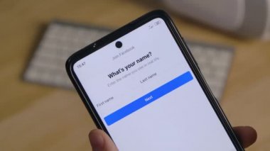 Editör görüntüleri: Akıllı telefon taşıyan beyaz bir adamın elleri ve giriş yapmak veya Facebook sosyal ağına kayıt olmak için dokunmatik ekranda klavye tuşları. Kapatın. Yavaş çekim.