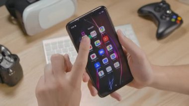 Editör görüntüleri: eSports turnuvalarına katılmak için akıllı telefondaki bir adamın elleri açık seğirme uygulaması. Canlı oyun yarışmaları. Eller yukarı. Telefon ekranını kapat. Yavaş çekim.