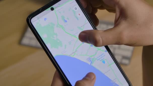 Editorial Footage: Mann nutzt Google Map App, um den interessanten Ort für zukünftige Reisen zu finden. Gps. Hands Draufsicht aus nächster Nähe. Zeitlupe. — Stockvideo