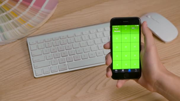 Redactionele beelden: Handen van een man met behulp van smartphone in verticale modus met groene scherm mockup, vegen vinger over het scherm, scrollen gebaren. Sluiten in slow motion. — Stockvideo