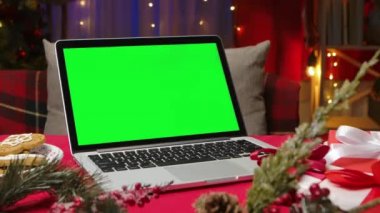 Arka planda Noel süslemesi olan yeşil ekran laptop. Reklam için yer, yeni yıl terfileri. Kromakey defter. Model monitörü. İnternetten alışveriş. Kutlama konsepti. Kapatın. Yavaş çekim