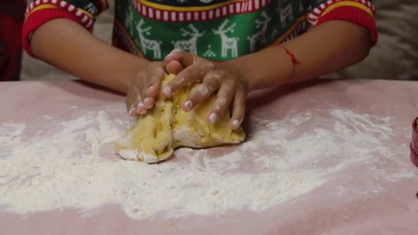 Pequena menina afro-americana em uma camisola de impressão de Natal preparando massa para biscoitos caseiros de Natal. Childs mãos em farinha de perto. Feliz Natal conceito. Movimento lento. — Vídeo de Stock