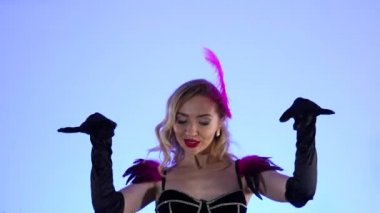 Muhteşem seksi burlesk dansçıları büyük siyah bir pastanın arka planına poz veriyorlar. Mavi stüdyo arka planında dans eden seksi kadınlar. Şenlikli tiyatro dans gösterisi. Kapatın. Yavaş çekim.