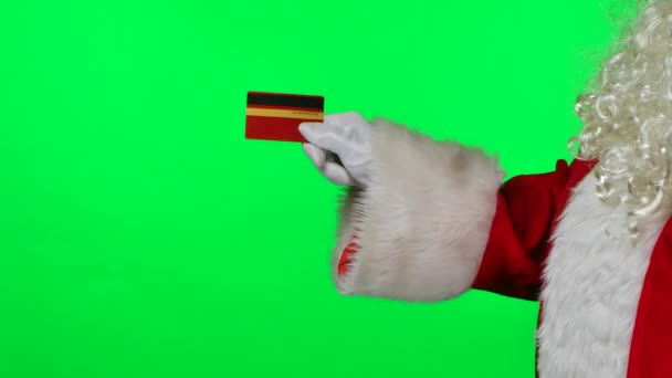 Бічний вид на Санта Клауса з бородою в білих рукавицях тримає кредитну картку в руках. Ізольований на зеленому екрані в студії. Ключ від хроми. Закрийся. Повільний рух. — стокове відео