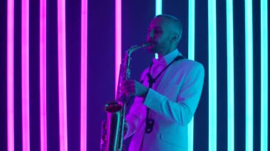Beyaz takım elbiseli bir saksafoncu solo çalar. Stüdyoda pembe ve mavi neon ışıkların arka planına karşı gösteri yapıyor. Yaklaşın, ağır çekim..