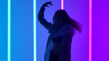 Stüdyoda ağır çekimde serbest dans eden genç bir kadın. Gençlik yaşam tarzı ve duygu konsepti. Kapat..