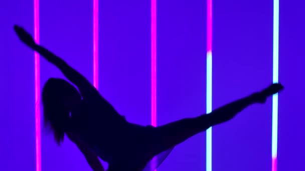 一个穿着透明衣服的女孩在明亮的霓虹灯管的衬托下跳舞的轮廓。芭蕾舞演员以慢动作表演带有现代性和芭蕾舞元素的舞蹈的舞蹈演员或芭蕾舞演员靠近点. — 图库视频影像