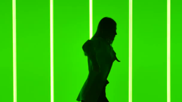 Стильная женщина танцует хип-хоп в студии на фоне ярких неоновых трубок. Фристайл импровизация. Силуэт. Медленная стрельба. Закрыть. — стоковое видео